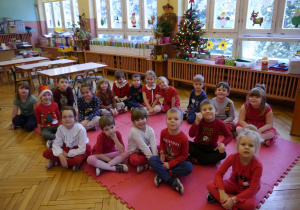 dzieci siedzą na dywanie w klasie